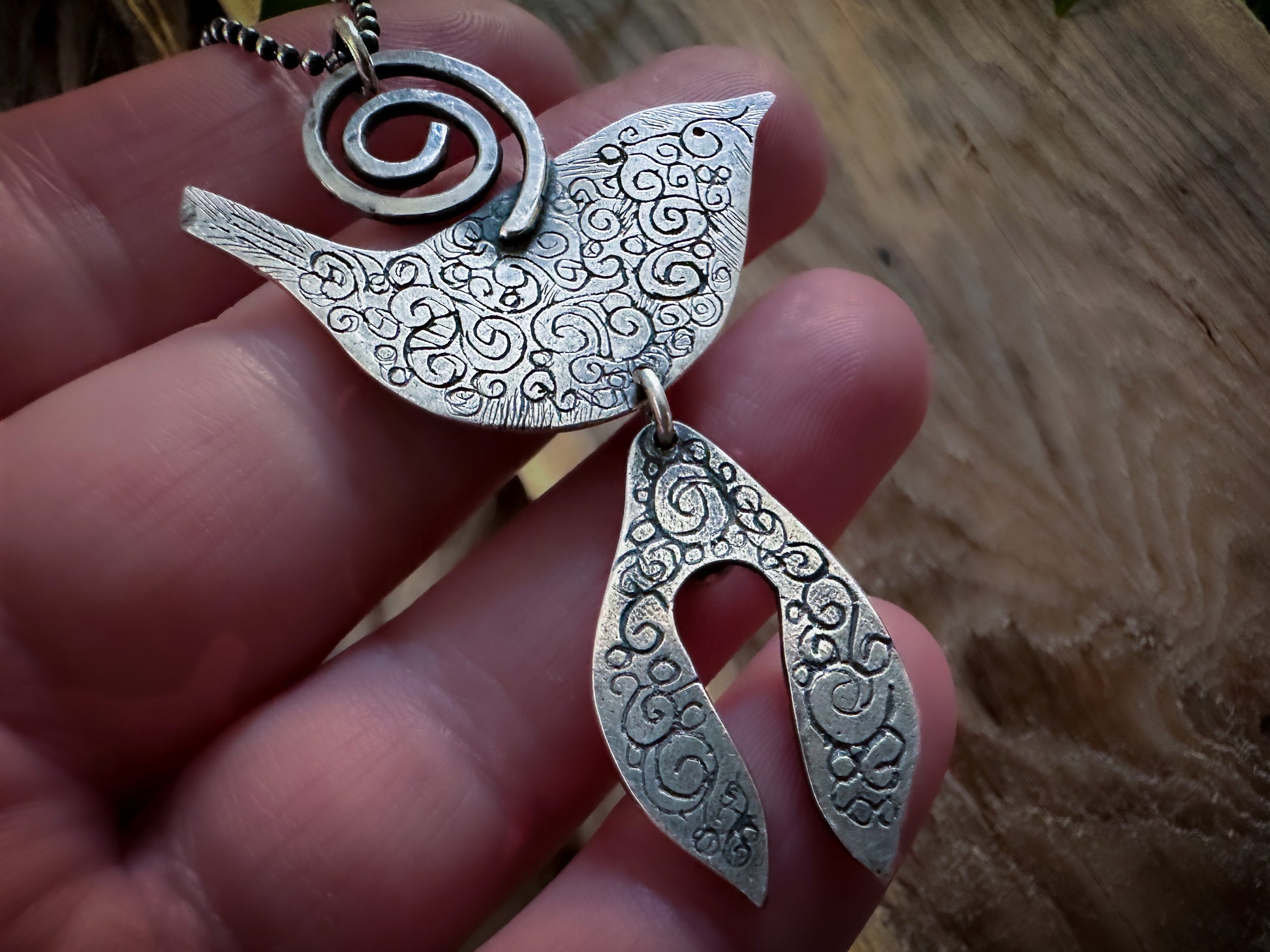 A back view of the Druid Bird, Wren and mistletoe pendant showing the intricate spiral design. By Silver Labyrinth