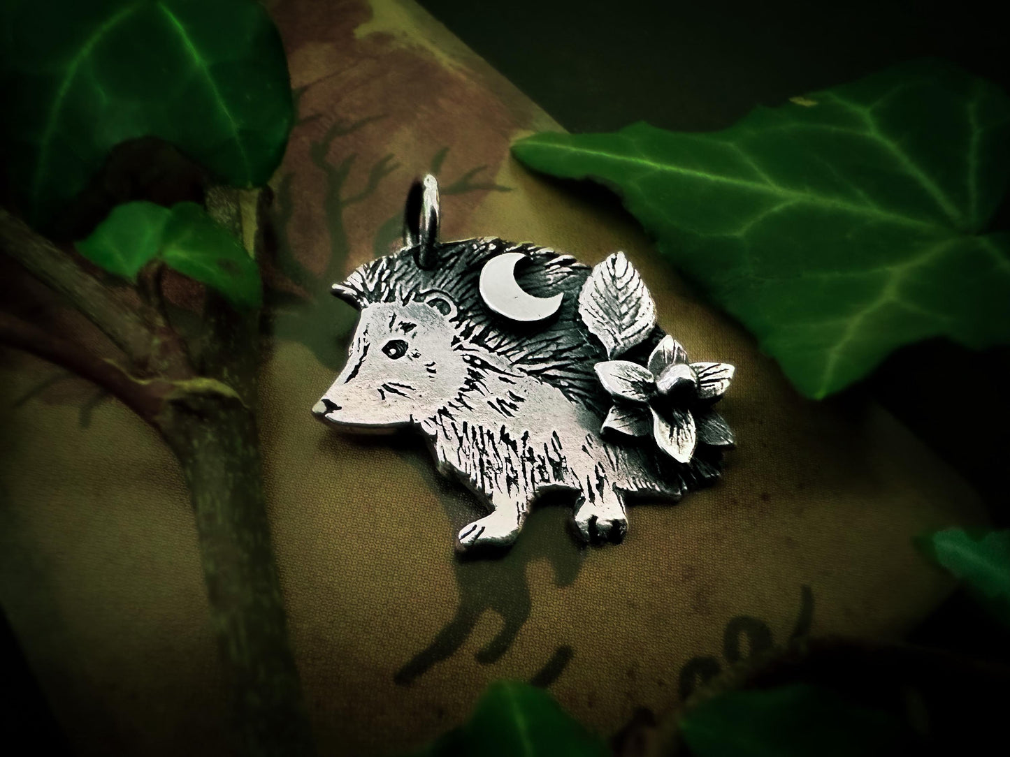 Close-up of this sweet and charming silver hedgehog pendant with crescent moon leaf and flower. By Silver Labyrinth Jewelry.