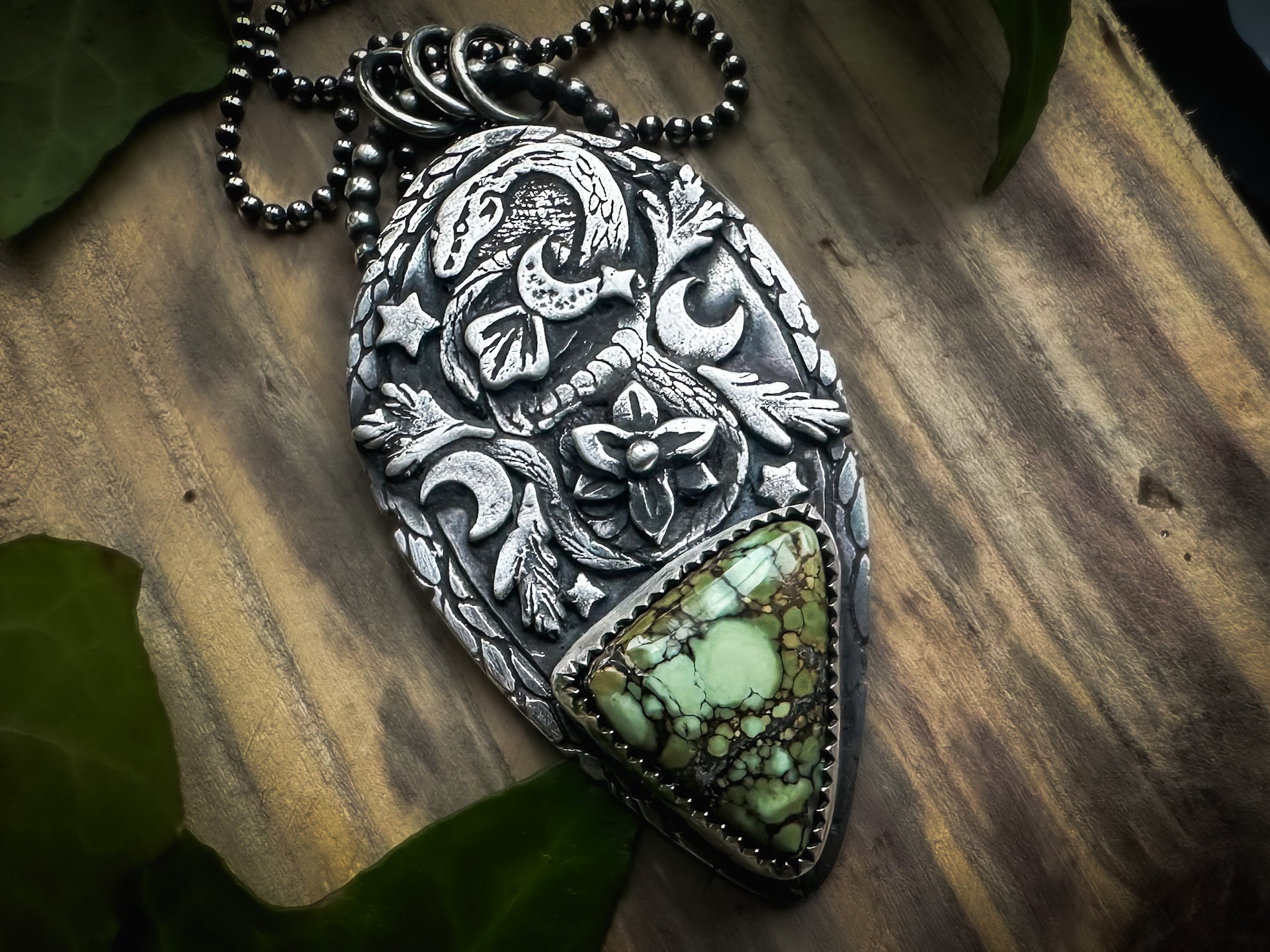 Handmade sterling silver totem pendant with a coiled snake, floral design, and a deep green Damele variscite. By Silver Labyrinth Jewelry 