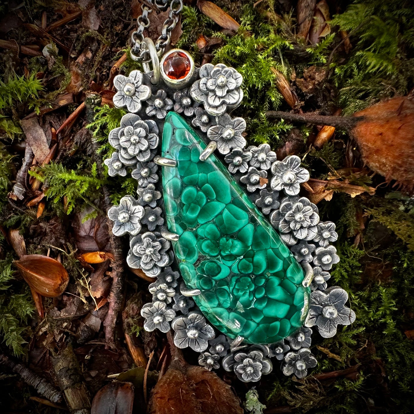 Stunning, collectors quality chatoyant malachite surrounded by a floral theme. Over 40 handmade silver flowers, prong set malachite, deep orange citrine. By Silver Labyrinth Jewelry