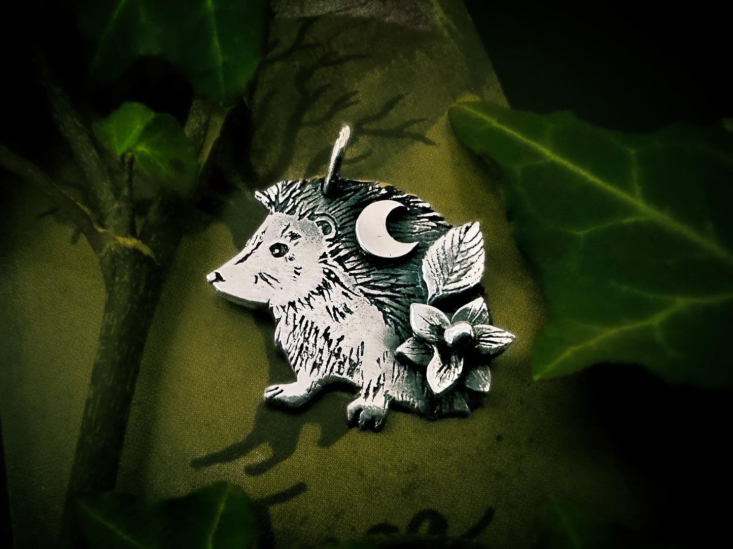 Naturalistc hedgehog pendant with a delicate flower, leaf and moon. Handmade by Silver Labyrinth Jewelry