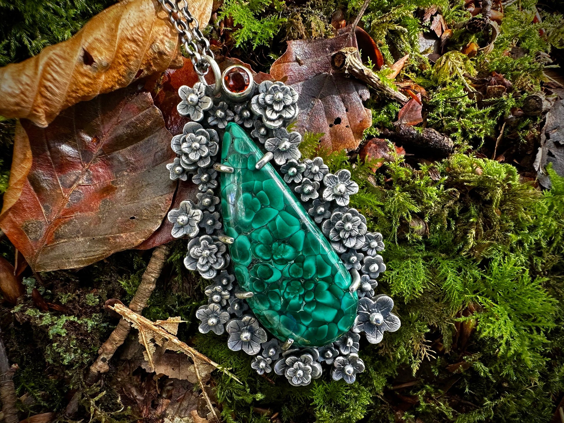 detailed view of vivid green, prong set malachite pendant. The pattern of flowers in the natural stone is reflected by over forty handmade flowers. With natural Maderia citrine. y Silver Labyrinth Jewelry