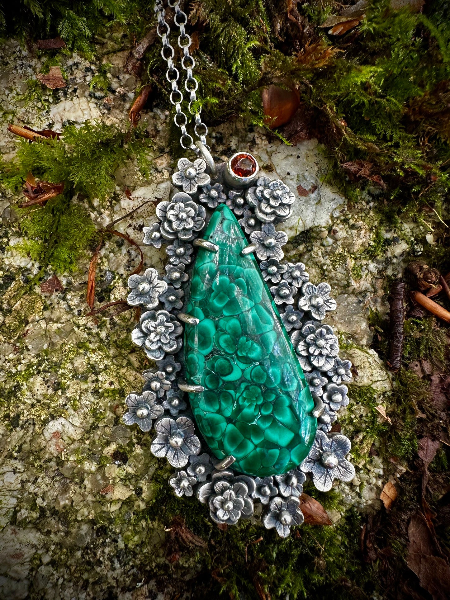 A portrait view of the chatoyant malachite catching the light. Exquisite details in this floral themed statement pendant. By Silver Labyrinth Jewellery