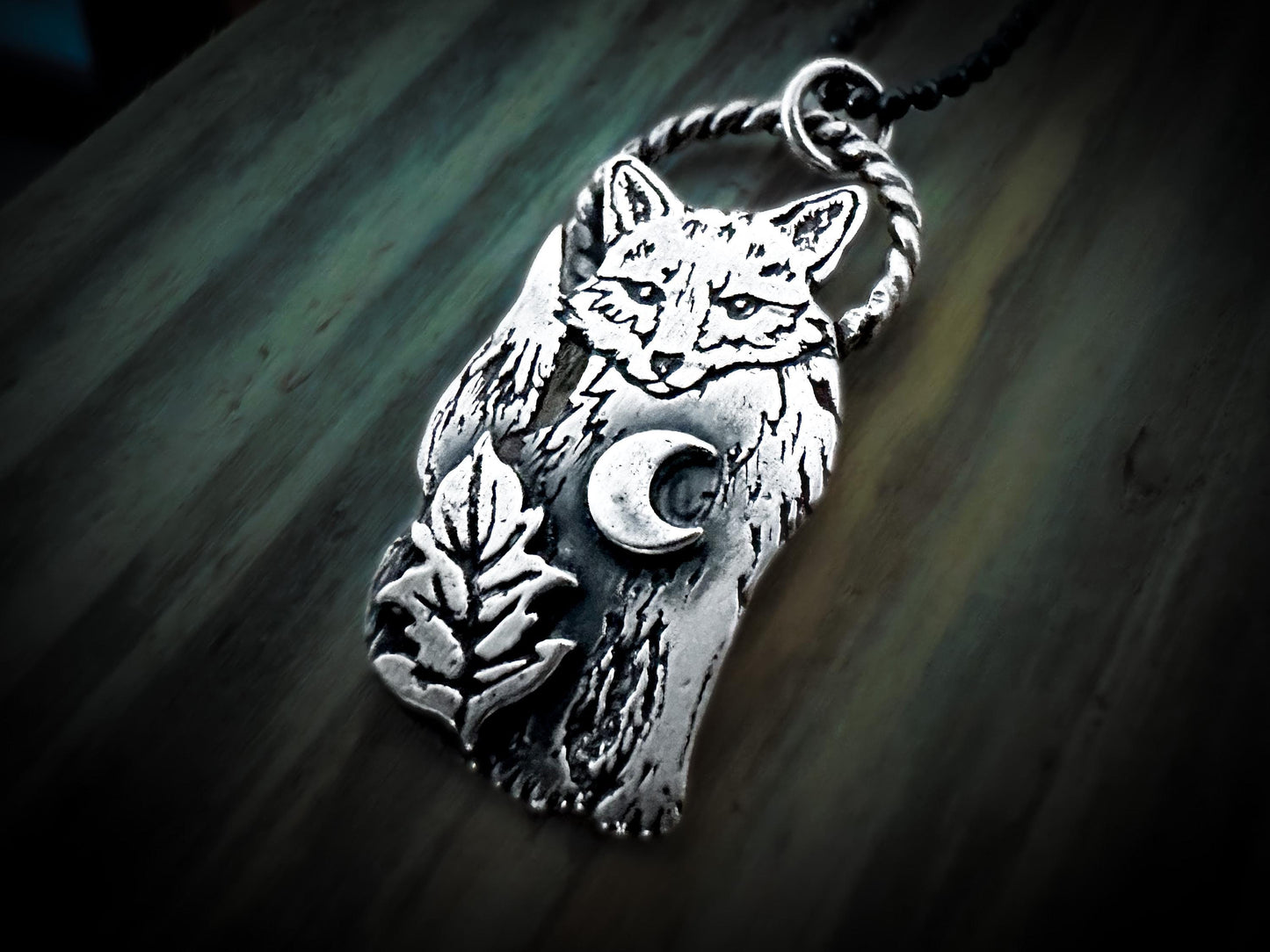 Detailed sterling silver fox on a twisted silver loop bail. With a crescent moon and leaf motif. Handmade by Jen Smith