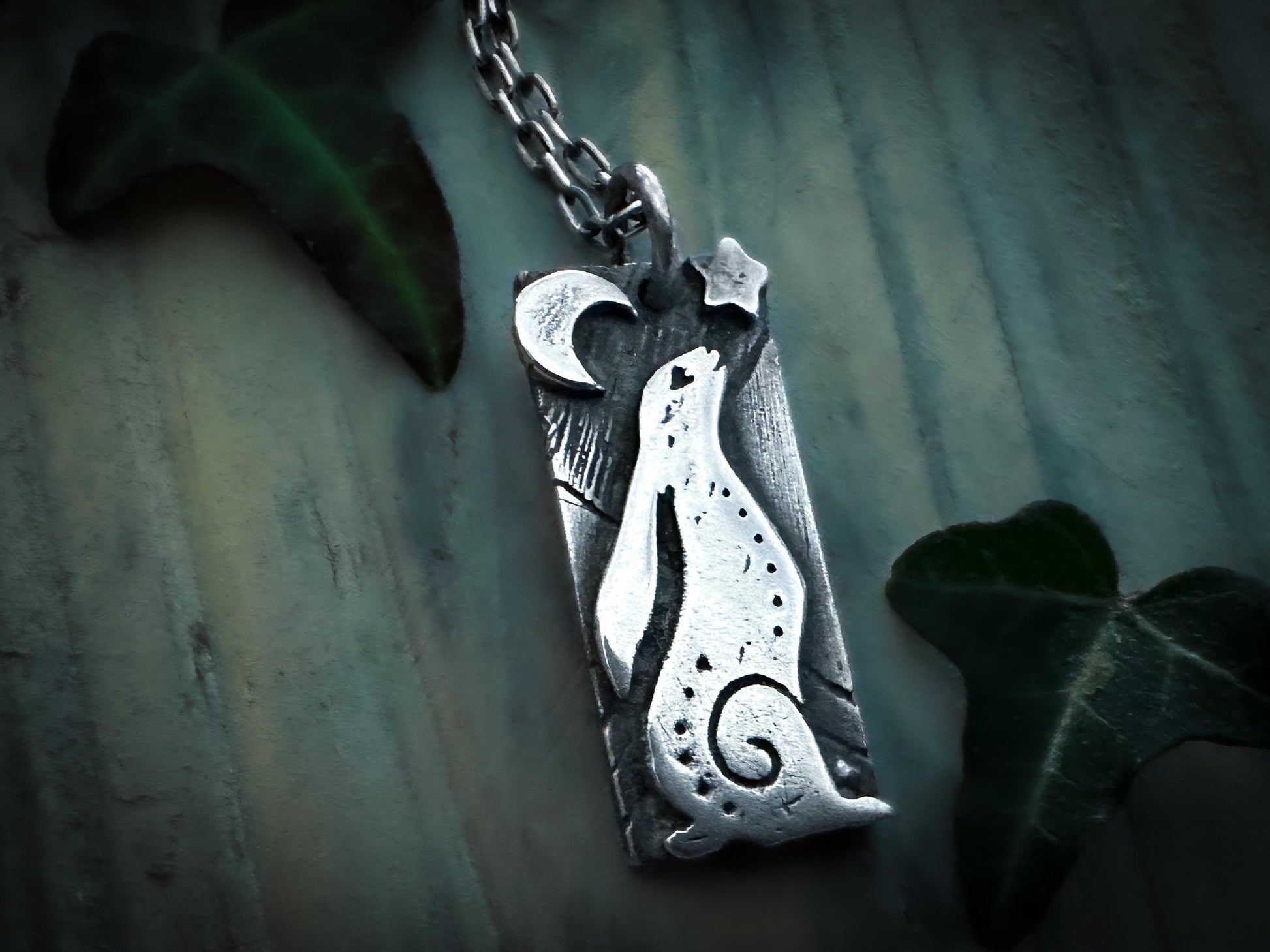 Front view of a little hare gazing at the night sky. With a star and crescent moon. Handmade in sterling Silver. Shown with chain. Silver Labyrinth Jewelry.