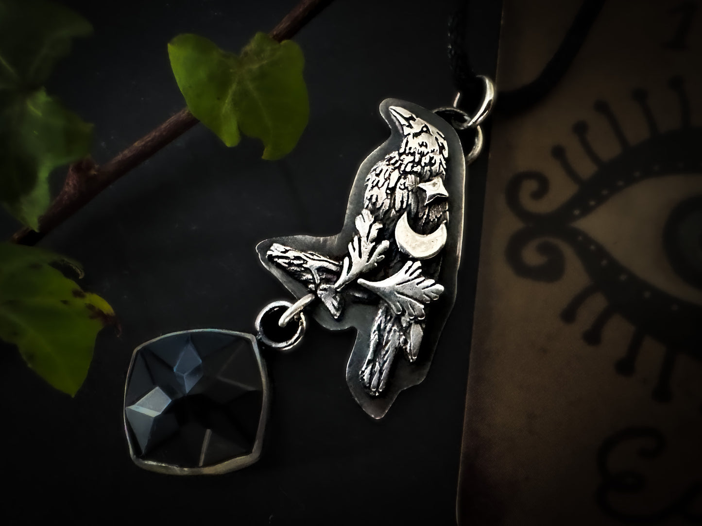 Intricately detailed crow pendant with fern motifs, black faceted stone and a vegan cord included. By Silver Labyrinth Jewelry 