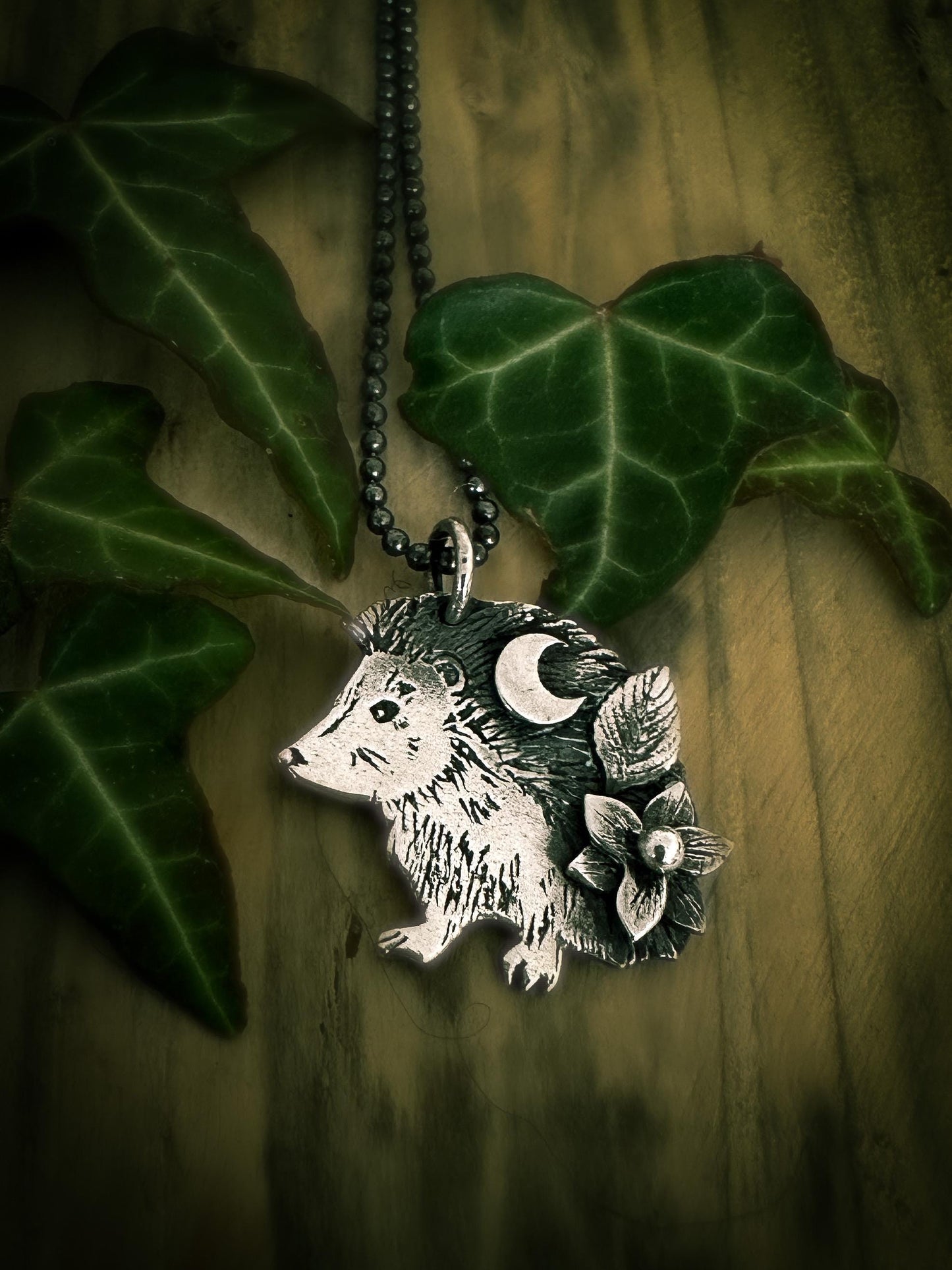 Showing the optional chain, the Little Hedgehog pendant, a side profile hedgehog with moon and botanical details. By Silver Labyrinth Jewelry