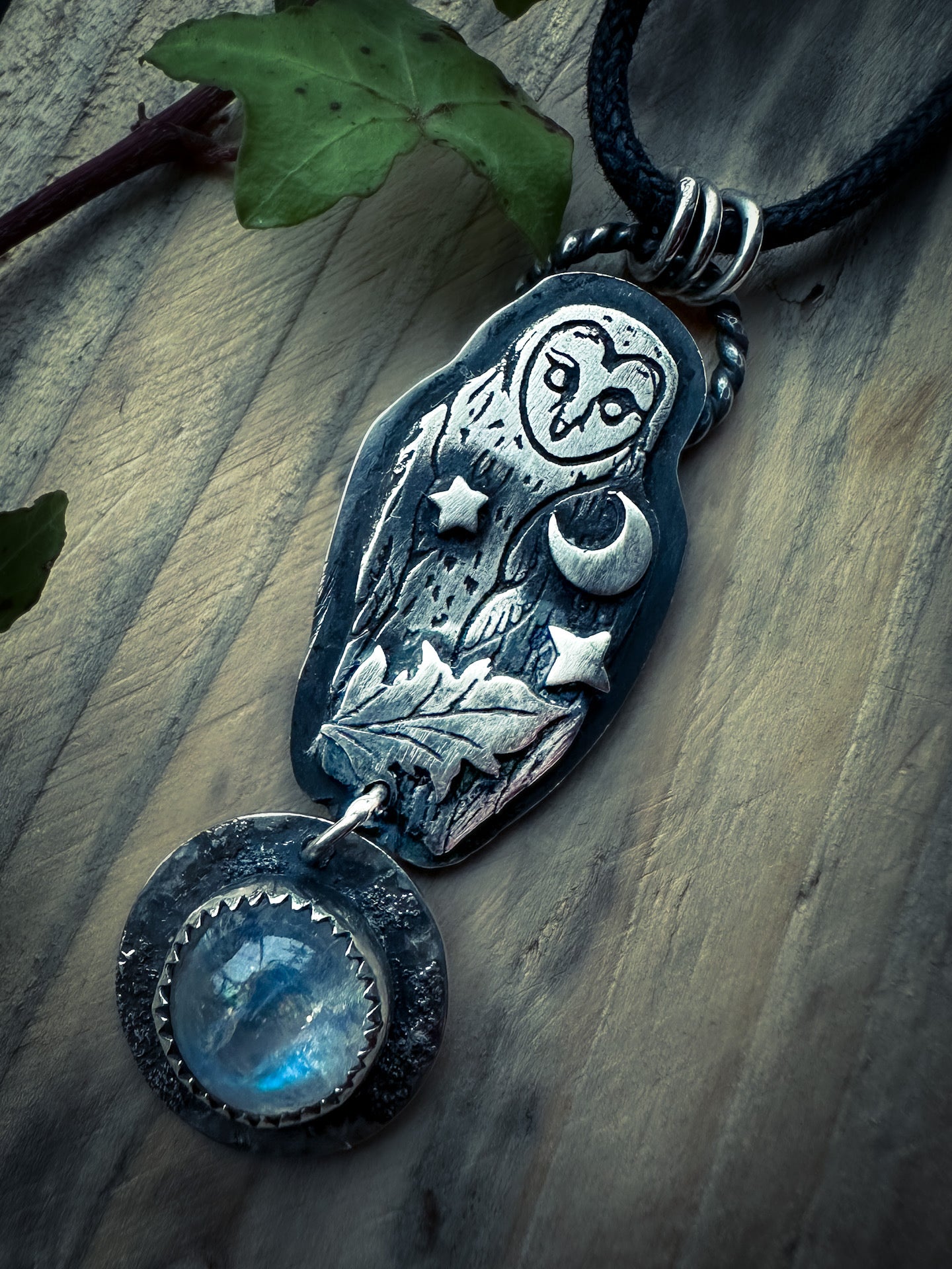 Rainbow moonstone pendant with detailed owl design and adjustable vegan cord.