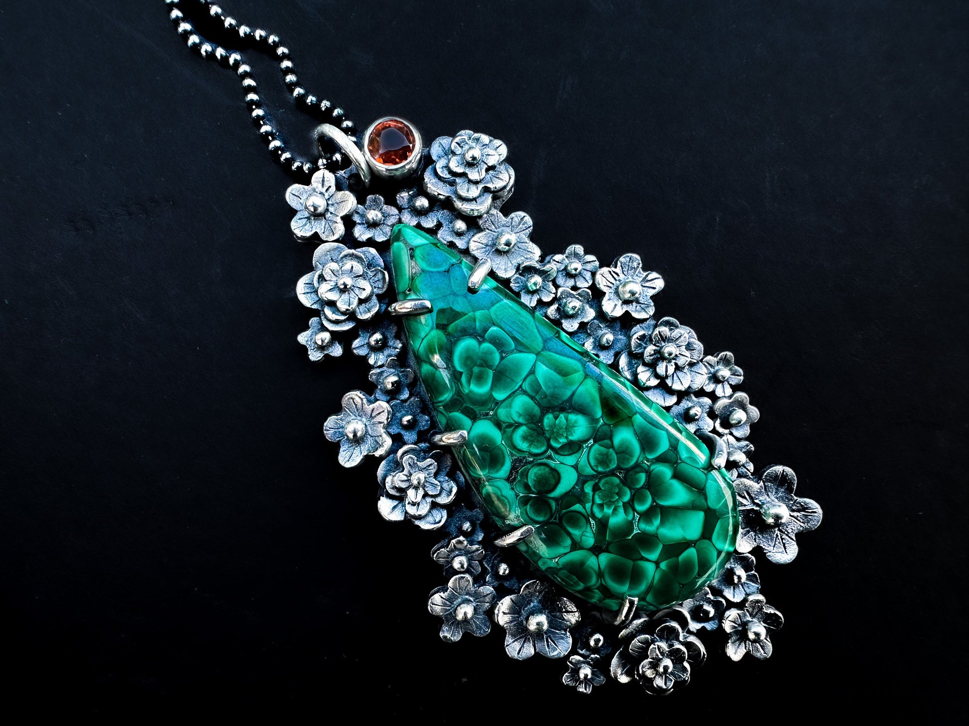 A stunning floral garden of a pendant. A stunning chatoyant malachite sits in a bed of handmade silver flowers with a tube set Madeira citrine. The Demeter pendant is inspired by the fertility of nature, by Silver Labyrinth Jewelry