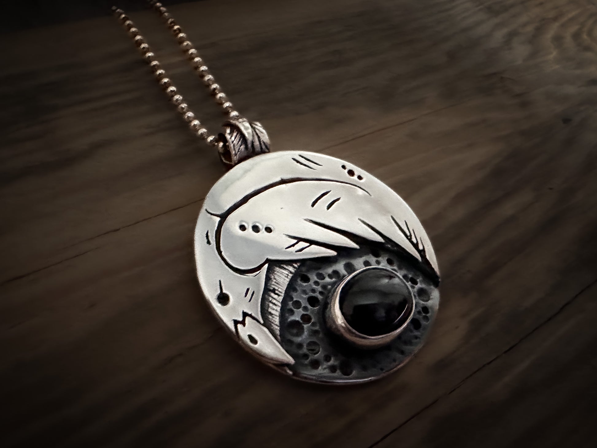 Nordic style raven, detailed in sterling silver with a black gemstone. By Silver Labyrinth Jewelry 