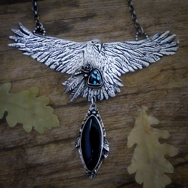 Handmade sterling silver raven pendant with detailed feathers and outstretched wings