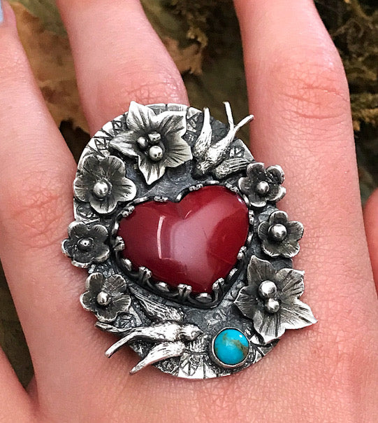 Gorgeous rosarita heart ring with a tattoo inspired theme of flowers and swallows. set with a small turquoise. Handmade by Silver Labyrinth Jewelry