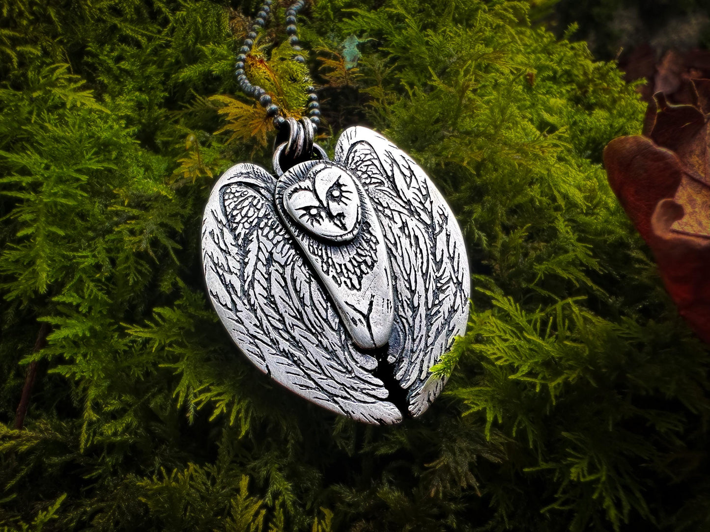 Shamanic owl pendant with expressive details. The wings are arched and decorated with feathers. The silver shines with a light polish and patinaed. By Silver Labyrinth Jewelry