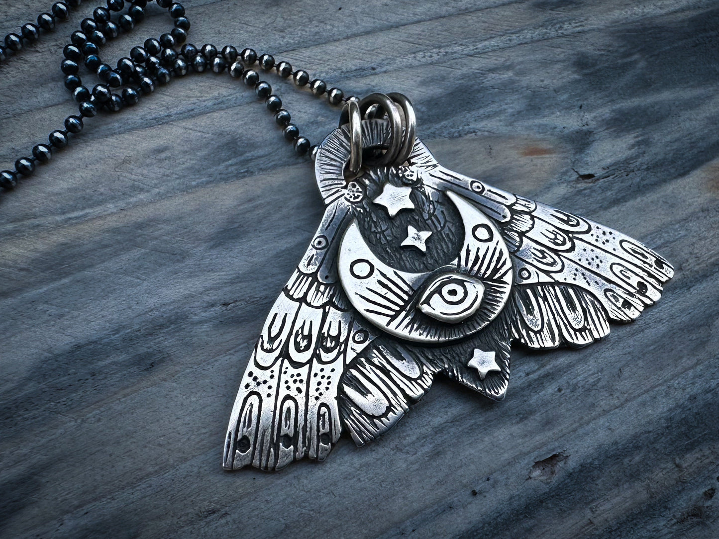 Silver Moth pendant symbolizing transformation and shadow-work, featuring celestial motifs and intricate details. By Silver Labyrinth Jewelry