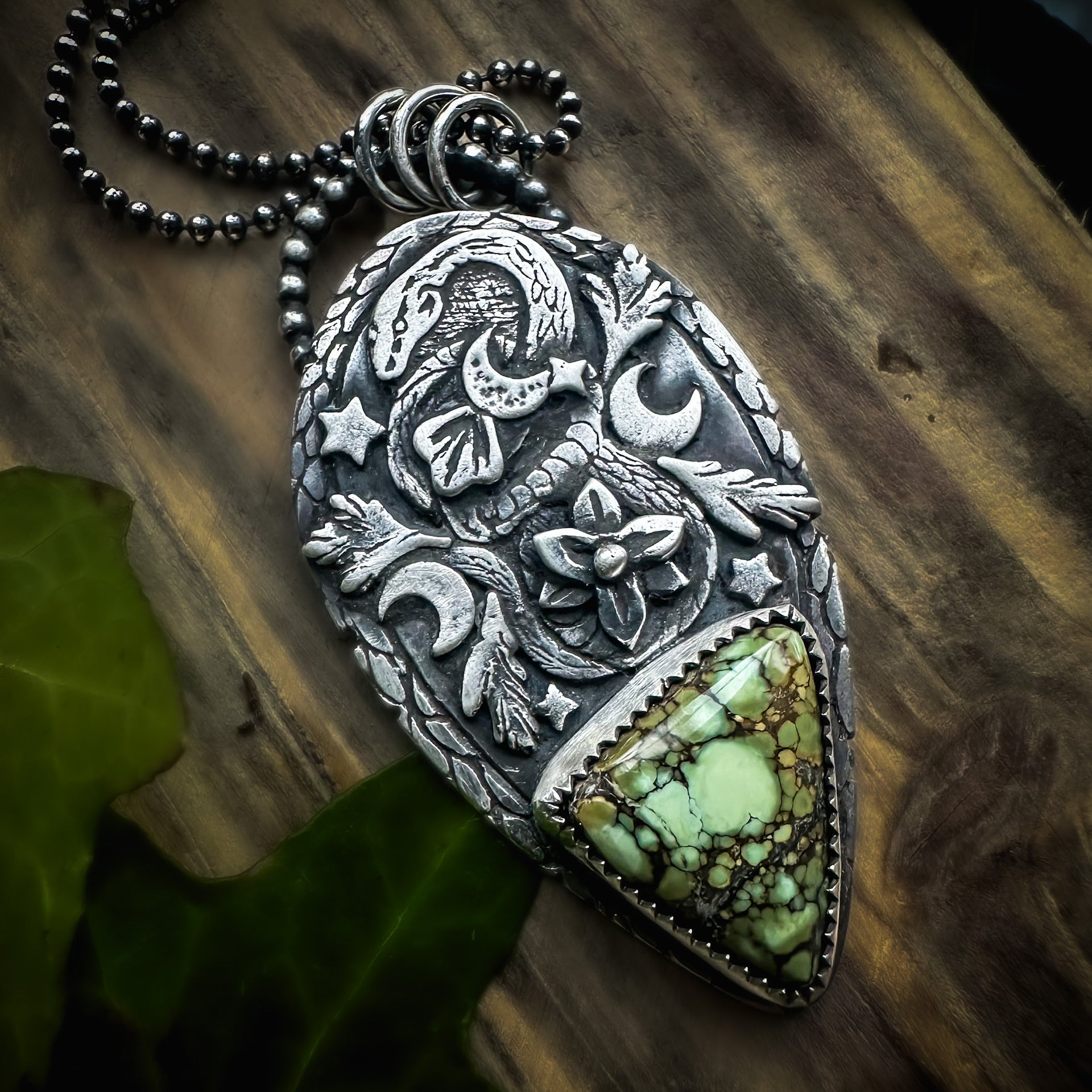 Hand-polished snake pendant in sterling silver, featuring a Damele variscite stone and nature-inspired motifs