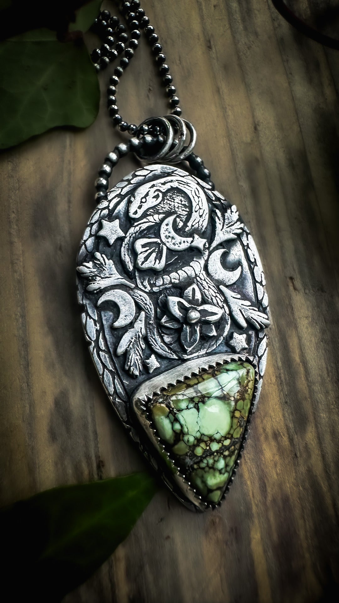 Sterling silver pendant with a snake, crescent leaf motifs, and a Damele variscite stone evoking grounding energy