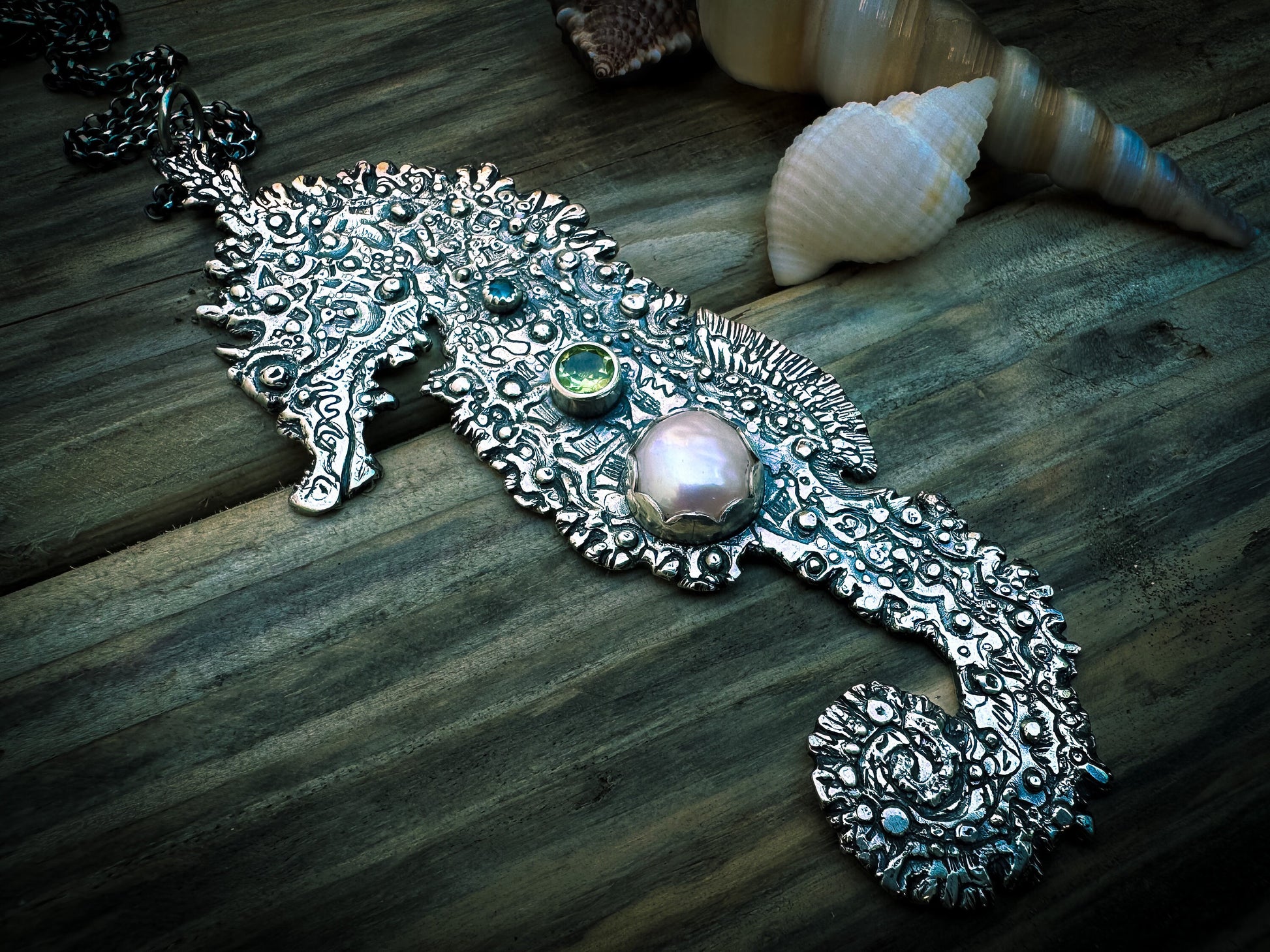 Statement silver seahorse pendant with intricate details and gemstones evoking the ocean’s energy. By Silver Labyrinth Jewelry 