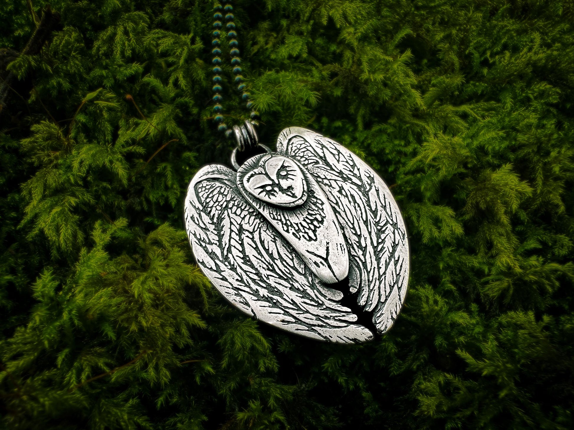 Stylized sterling silver owl pendant, symbolizing shamanic connection and wild magic in an animal-inspired design.