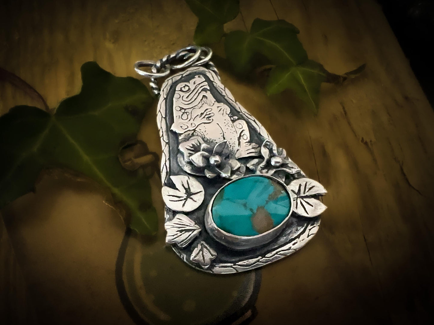 Exquisite detail on this handmade sterling silver toad. Aorned with Lillies and leaves and set with a rare natural American Carico Lake turquoise.