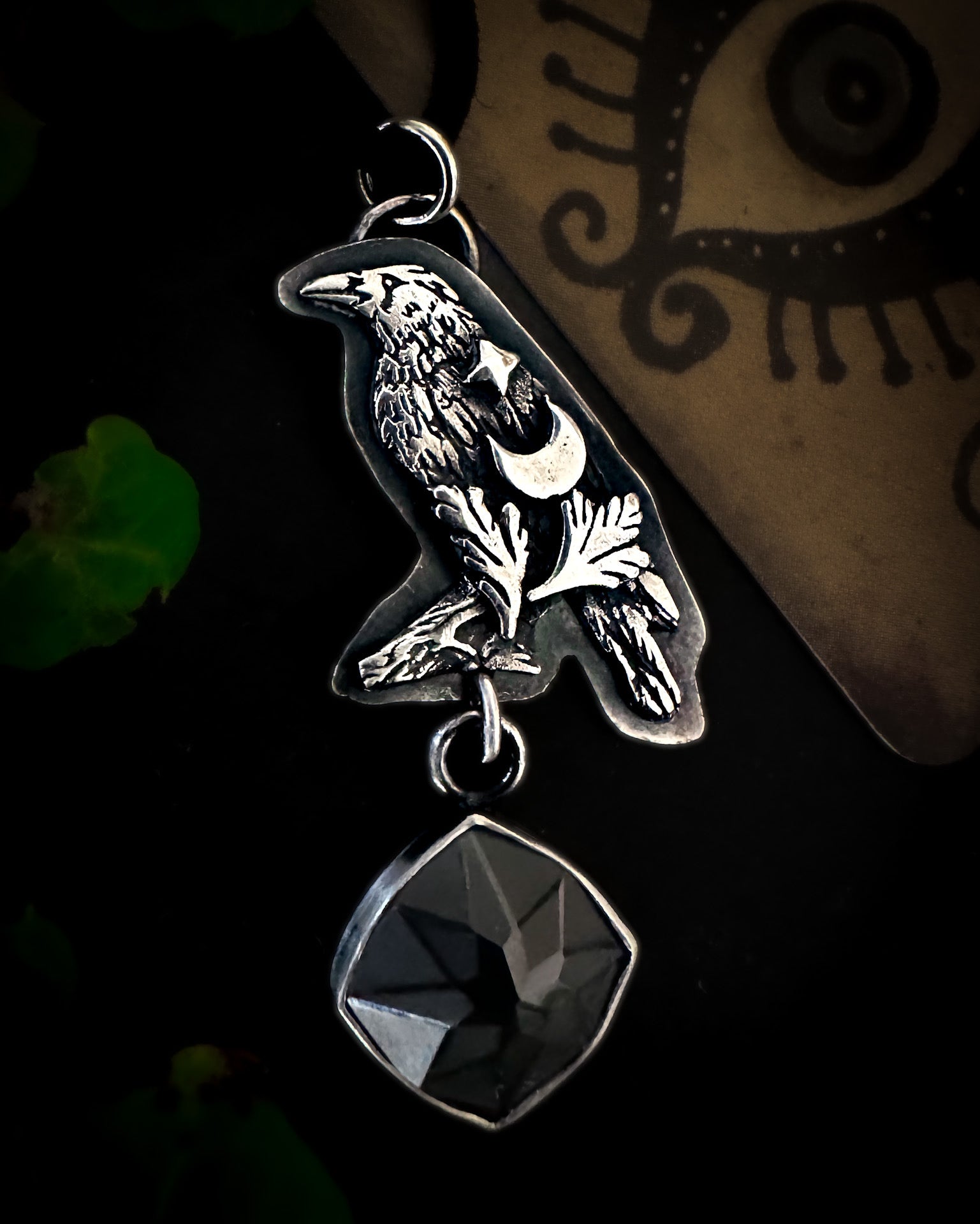 Handmade sterling silver crow pendant with witchy motifs, celebrating magical familiars