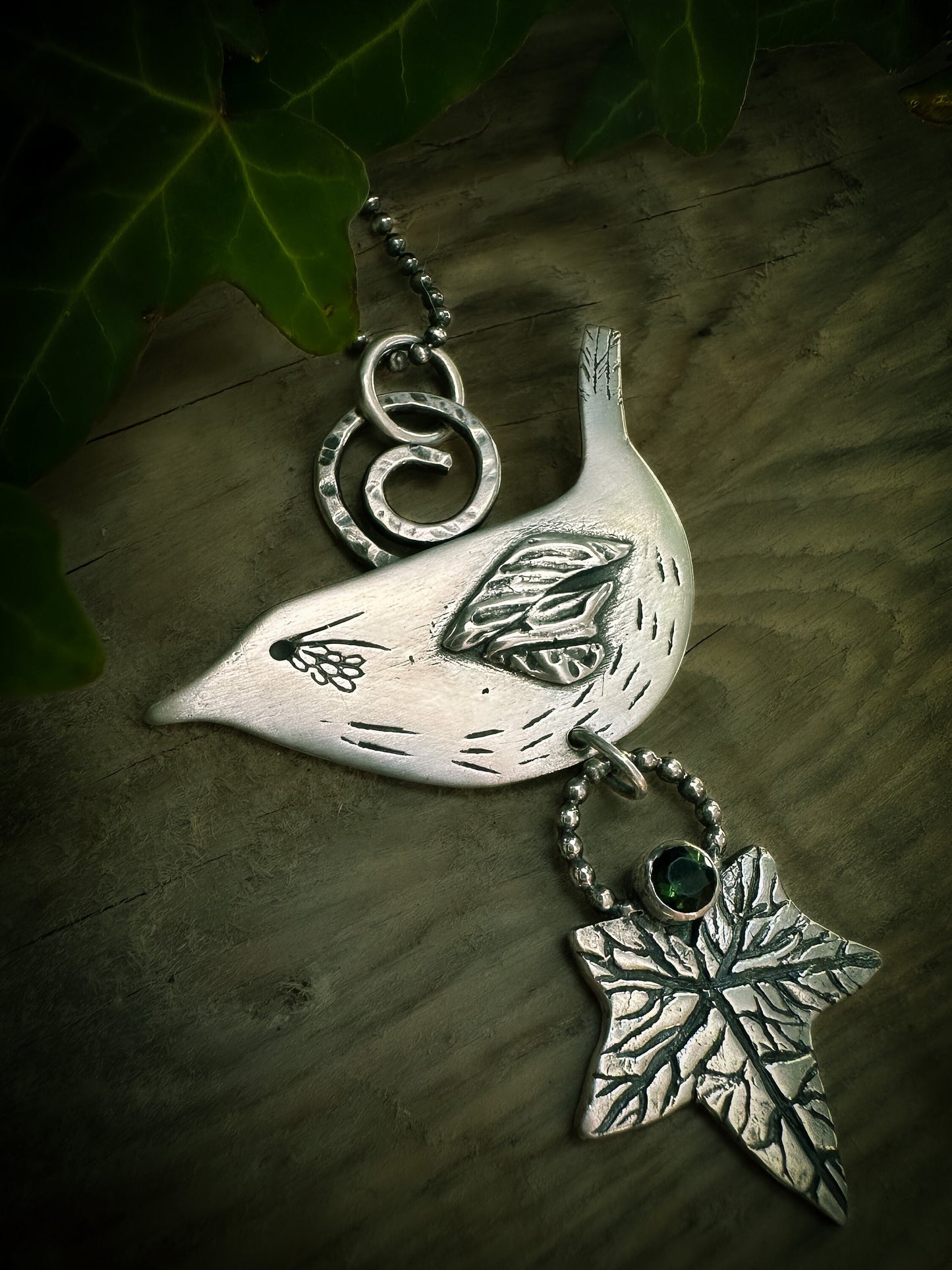 Close-up of handmade, sterling silver Druid Bird Wren pendant. With ivy leaf and tourmaline. By Silver Labyrinth Jewelry