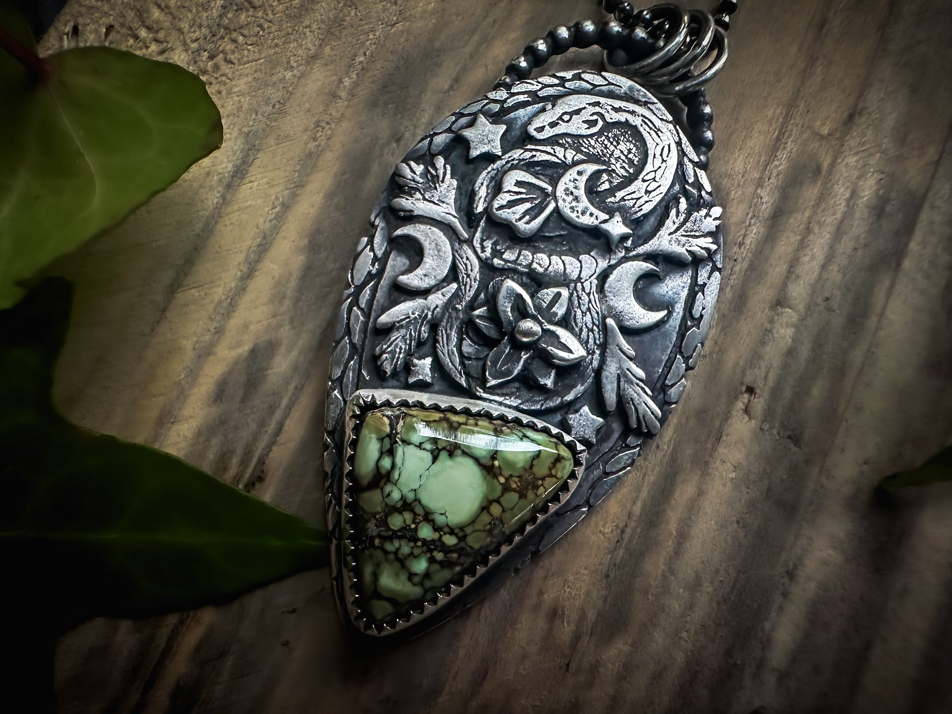 Handmade sterling silver pendant with a coiled snake, rare Damele variscite, and intricate nature-inspired details