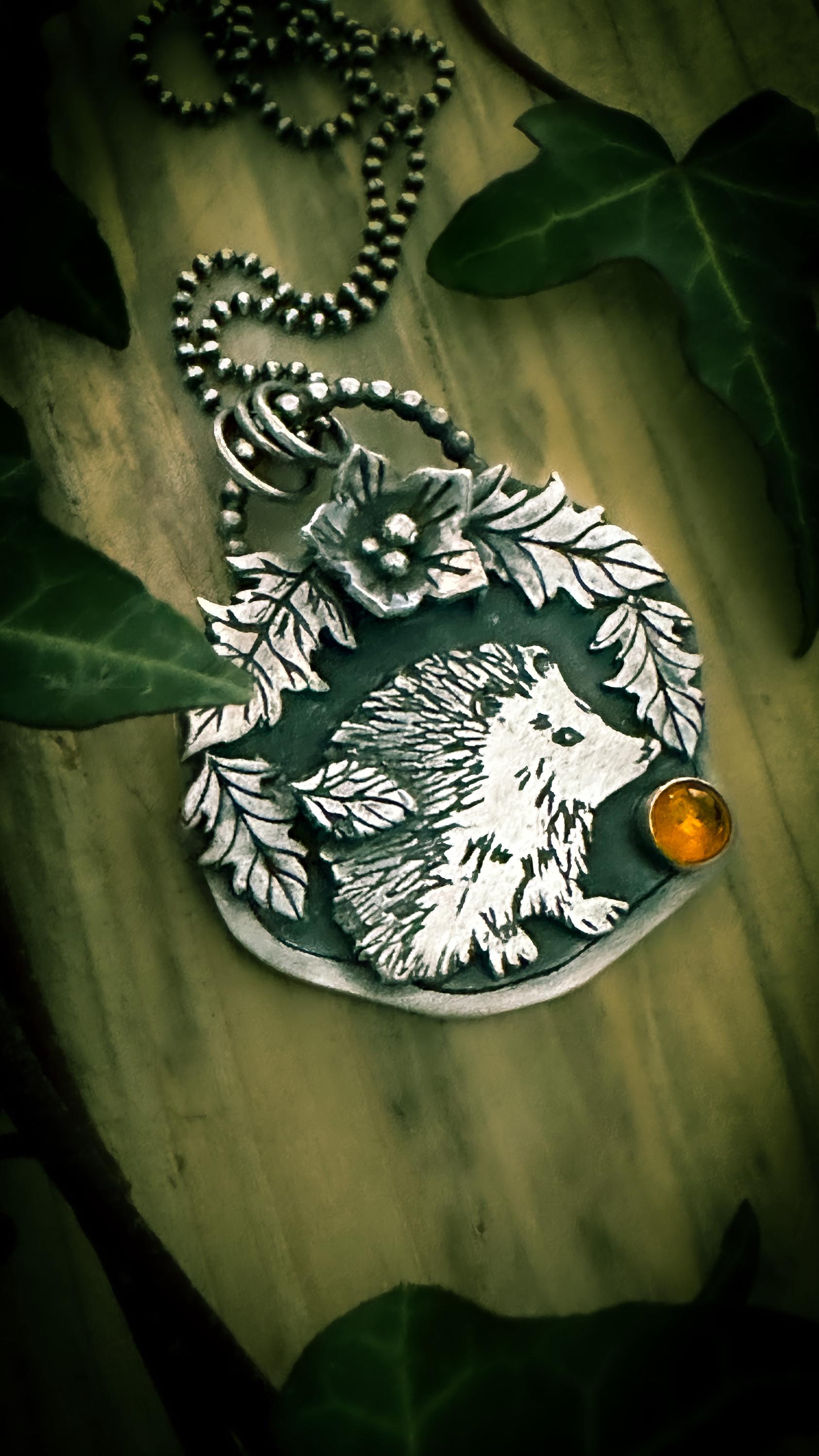 Side of centre view of hedgehog pendant, with a bezel set amber cabochon. By Silver Labyrinth Jewelry