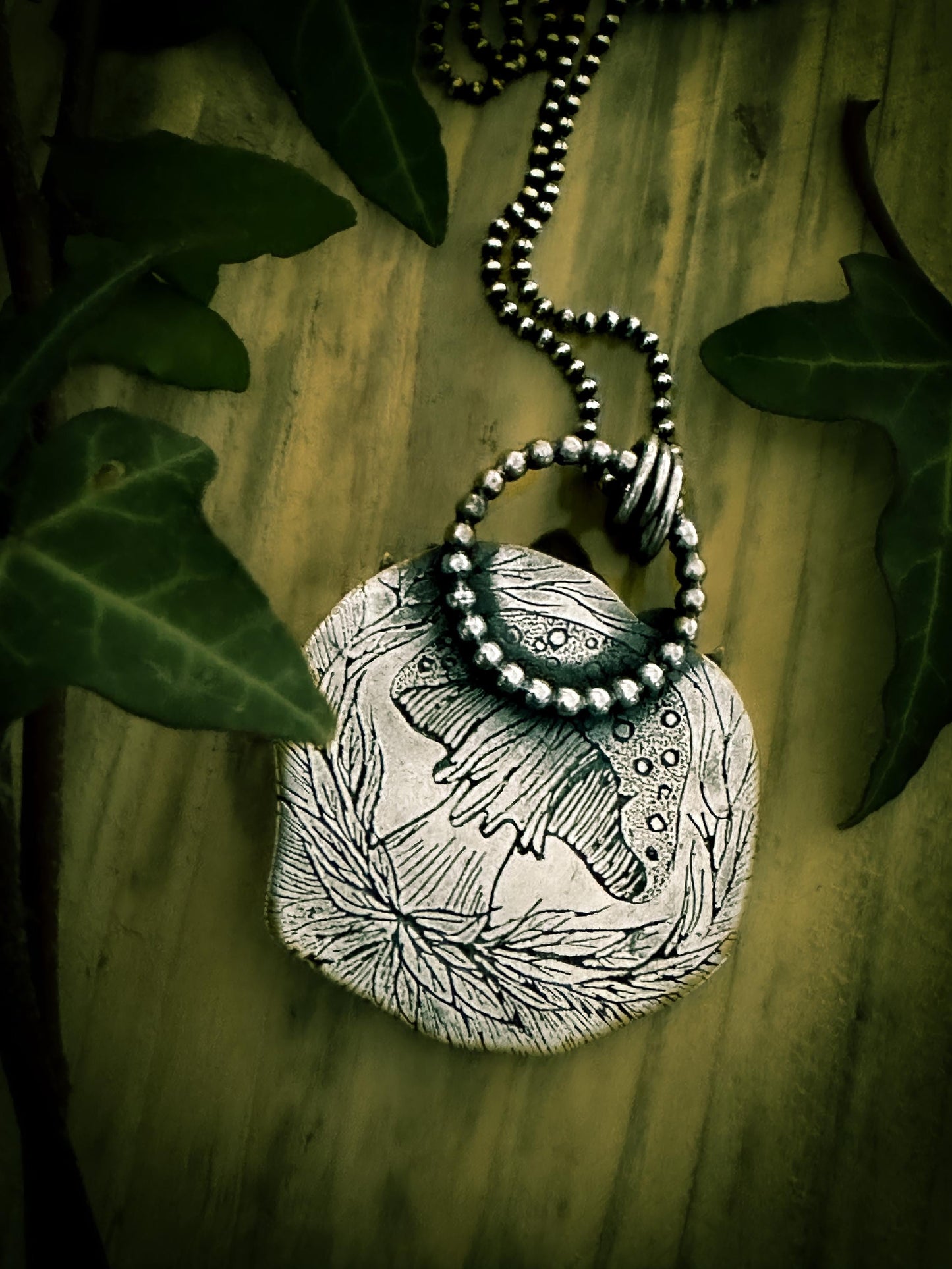 Back view of hedgehog pendant, showing detailed toadstool in the woods. By Silver Labyrinth Jewelry